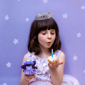 Front view of a young girl holding a cupcake in one hand and Bluebell The Birthday Fairy in the other.