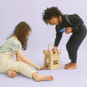 Front view of two young children playing with dolls and the Rattan Castle Bag.