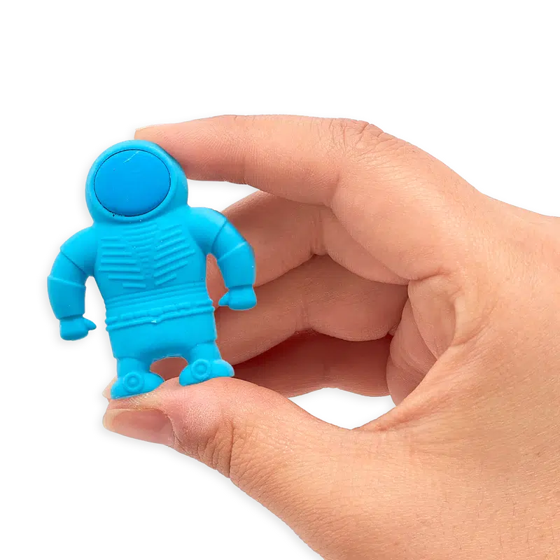 Front view of a person&#39;s hand holding the blue astronaut eraser in between their thumb and forefinger.