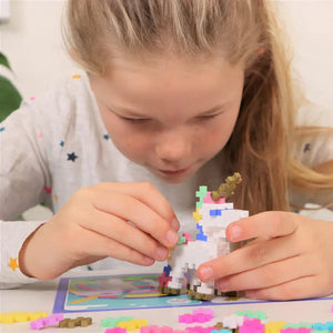 Front view of a young girl assembling a unicorn from Plus Plus Learn to Build Unicorns set.