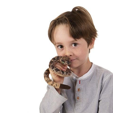Rattlesnake finger puppet on child&#39;s hand. 