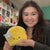 Front view of young woman holding snacker taco in her hands.