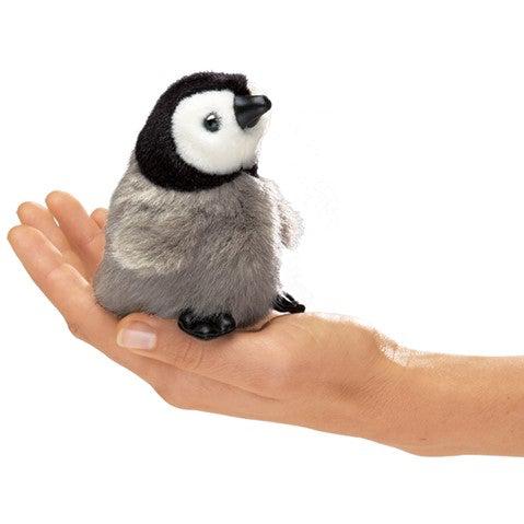 Cute baby penguin finger puppet sitting in an adult's palm