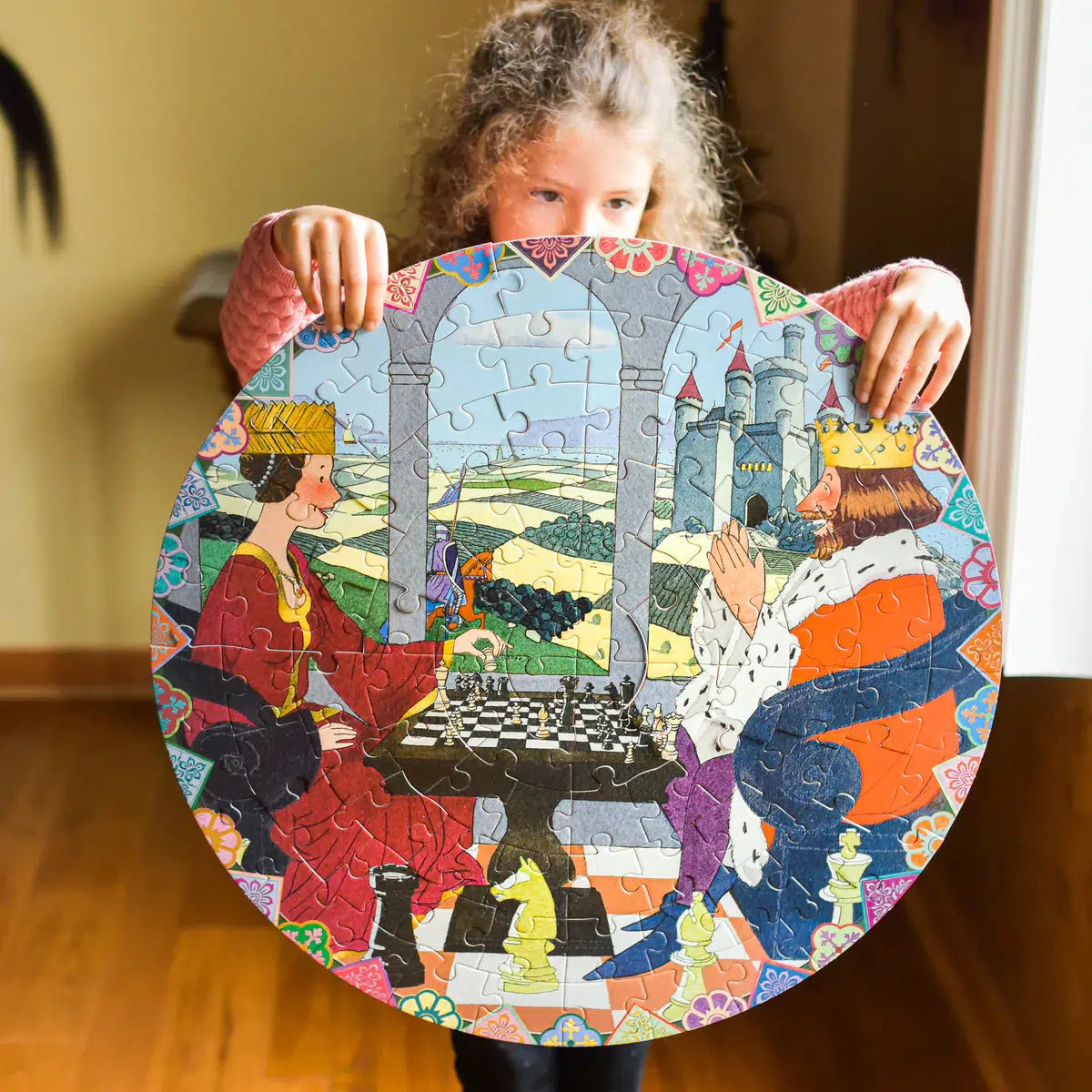Front view of a child holding the completed round Queen&#39;s Gambit puzzle.