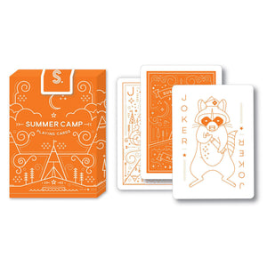 Front view of the summer camp playing cards in the box. Three cards are stacked to the right of the box. 