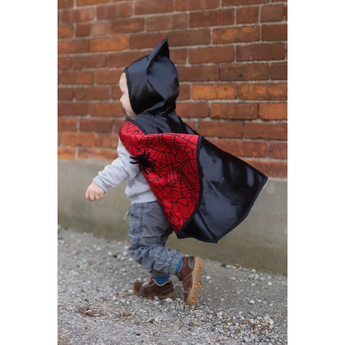 Side view of a child wearing the cape with the bat side on the outisde.