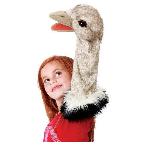 Ostrich stage puppet on a red haired girl&#39;s arm, as she looks up and smiles at the puppet