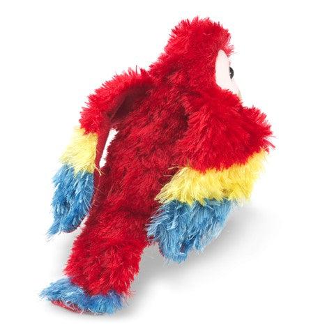 Mini scarlet macaw finger puppet on hand. 