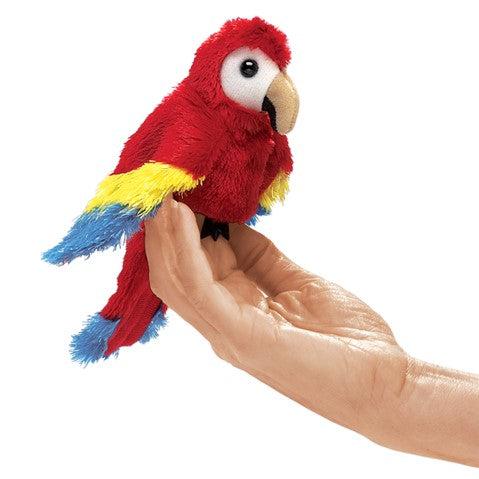 Mini scarlet macaw finger puppet on hand. 