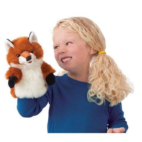 Little fox puppet for little hands on the hand of a blonde girl with blue shirt.