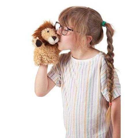 Lion puppet being kissed on the cheek by a girl with braids and glasses.