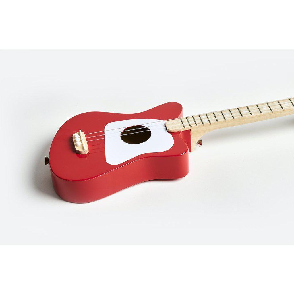 Angled side view of the red mini Loog guitar, showing the front and side of the guitar.