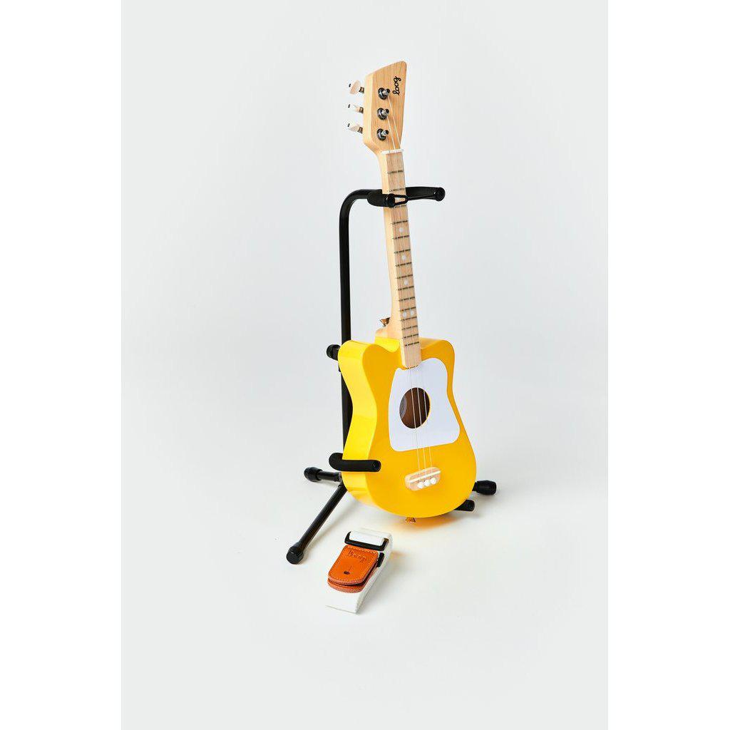 Front view of the mini yellow guitar in a stand.