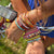 Front view of a person showing their wrists with stacks of bracelets made with the loopdedoo loom kit.