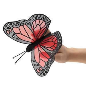 Front view of the Mini Monarch Butterfly Finger Puppet on a person's finger with the wings spread out.