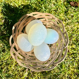 Top view of a basket with 5 magic eggs inside it, showing how the colors shift in the sunlight.