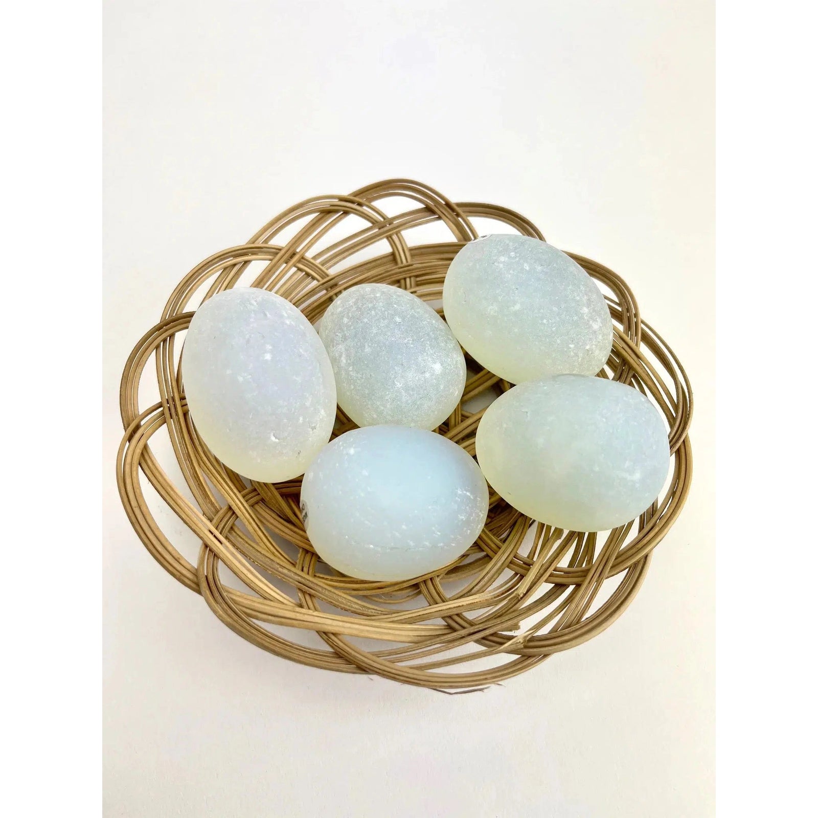 Top view of a basket with 5 magic eggs inside it, showing how the colors shift in the sunlight.