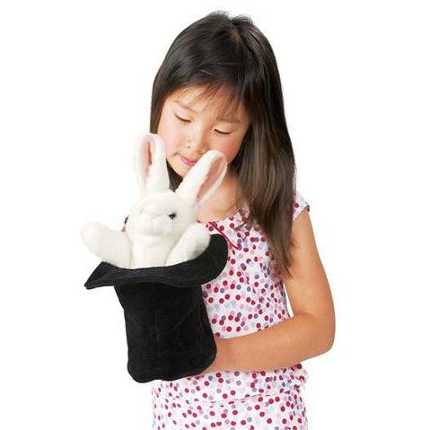 Front view of a child playing with the rabbit in a hat puppet.