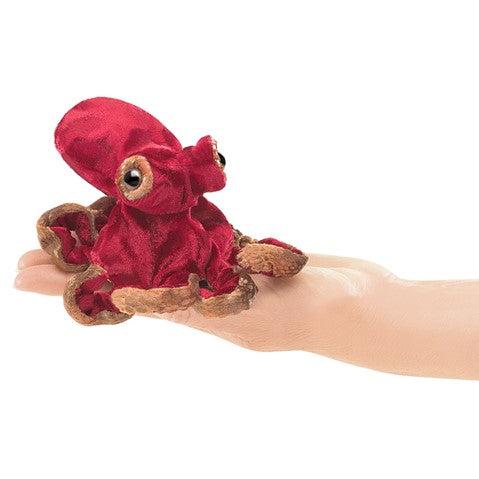 Red octopus finger puppet in hand. 