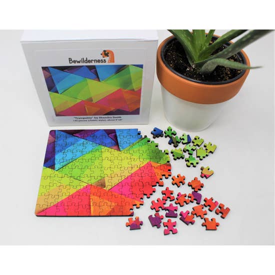 Puzzle box with partially assembled puzzle featuring translucent, rainbow-colored, overlapping triangles.